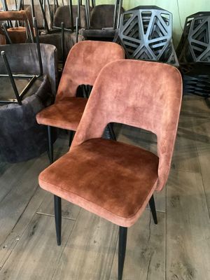 Plusieurs chaises sont alignées en rangée sur un plancher en bois