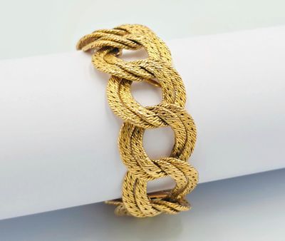 a close up of a gold rope bracelet on a napkin