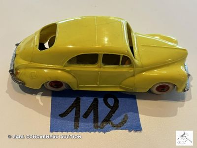 une petite voiture jaune posée sur une feuille de papier bleue
