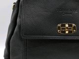 black leather handbag with gold hardware and handle on a white background