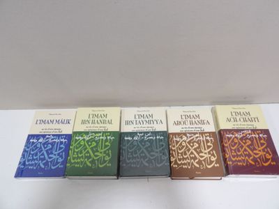 four books on a white table with a white wall in the background