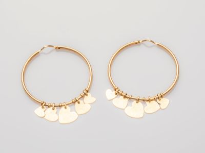 une paire de boucles d'oreilles créoles en or ornées de pendentifs en forme de cœur