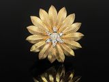 a gold and diamond flower broochle