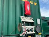un gros camion vert avec un feu rouge à l'arrière