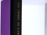 purple and black book on a shelf with a white background