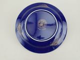 a close up of a blue plate with a gold design on it