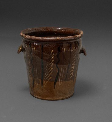 a brown vase that has some writing on it