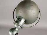 a silver lamp that is on top of a metal pole