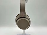 the sony headphones are sitting on a stand on a white surface