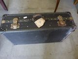 a black suitcase sitting on the floor with a tag on it