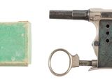 un petit pistolet avec un porte-clés à côté d'une boîte de savon
