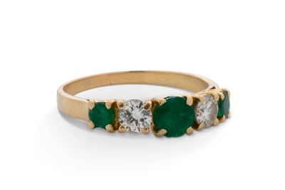une photo d'une bague sertie de trois pierres, d'émeraudes et de diamants