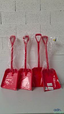 quatre pelles en plastique rouges posées sur une table blanche