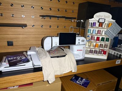 a sewing machine sitting on top of a desk next to other sewing supplies
