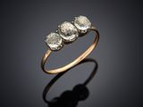 une bague en or sertie de trois diamants blancs sur fond noir