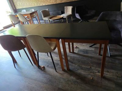 de nombreuses chaises et tables dans une pièce dotée d'une grande fenêtre