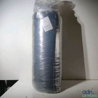 un grand rouleau de tissu bleu emballé dans du plastique, posé sur une table