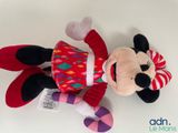 minnie mouse plush toy laying on a white surface with a red and pink dress
