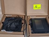 deux cartons contenant des ordinateurs portables, posés par terre