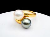 une photo en gros plan d'une bague ornée de deux perles