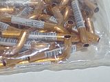 a bag of gold colored tubes in it on a table