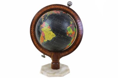 une image représentant un petit globe terrestre posé sur un socle blanc