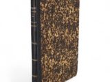 a brown and black book sitting on top of a white surface