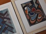 two framed art pieces on a wooden table