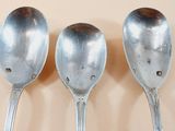 three spoons that are lined up on a table