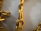a gold chain that has been placed on a white surface
