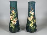 une paire de vases décorés de fleurs, posés sur une table