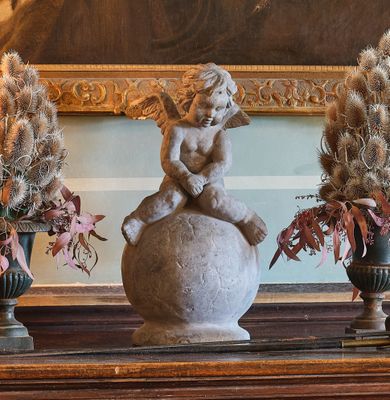 trois vases remplis de fleurs et une statue posés sur une table