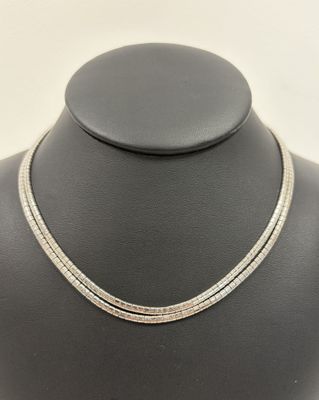 a white gold necklace with two rows of diamonds on a mannequin