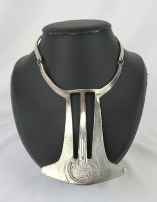 une photo d'un collier en argent sur un mannequin noir