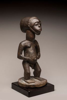 une image représentant la statue d'un homme debout sur un socle en bois