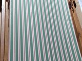 a green and white striped bed in a small room