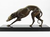 sculpture en bronze représentant un lévrier, posée sur un socle noir, sur fond blanc