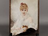 une vieille photo représentant une femme avec un chat posé sur une table