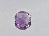 a close up of a purple gemstone on a white surface