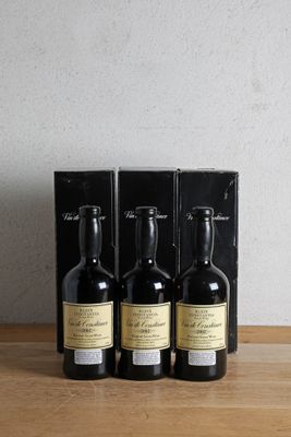 trois bouteilles de vin posées sur une table en bois