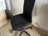 a black office chair that is sitting in the corner of a room