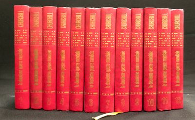 Six livres rouges sont alignés sur une surface noire, avec une banane devant eux