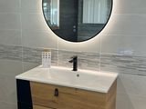 une salle de bains avec un lavabo et un miroir au mur