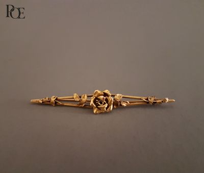une image représentant une broche en or ornée de fleurs