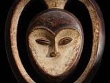 gros plan d'un masque en bois accroché au mur