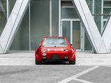 a small red car parked in front of a building