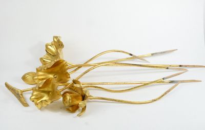 a gold flower brooch on a white surface