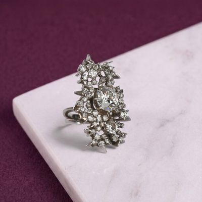 une photo d'une bague en diamant posée sur une dalle de marbre