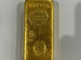 deux lingots d'or posés côte à côte sur une surface blanche
