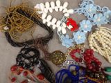 a lot of necklaces and bracelets that are on a table